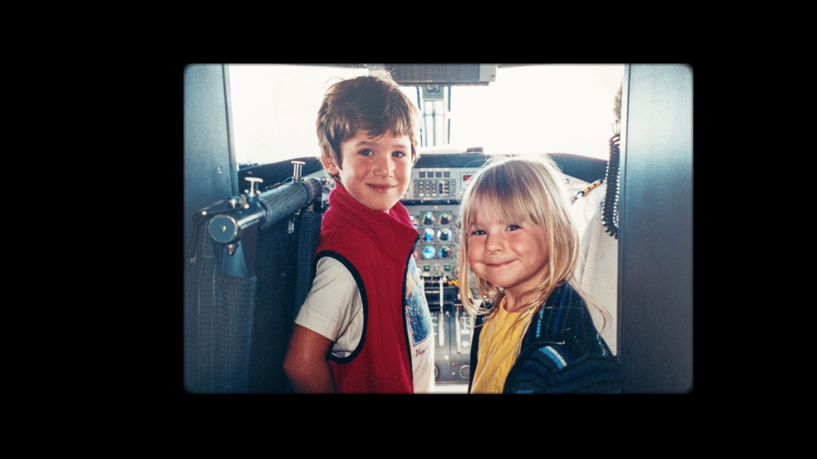 Vintage photo of two young children in an airplane cockpit
